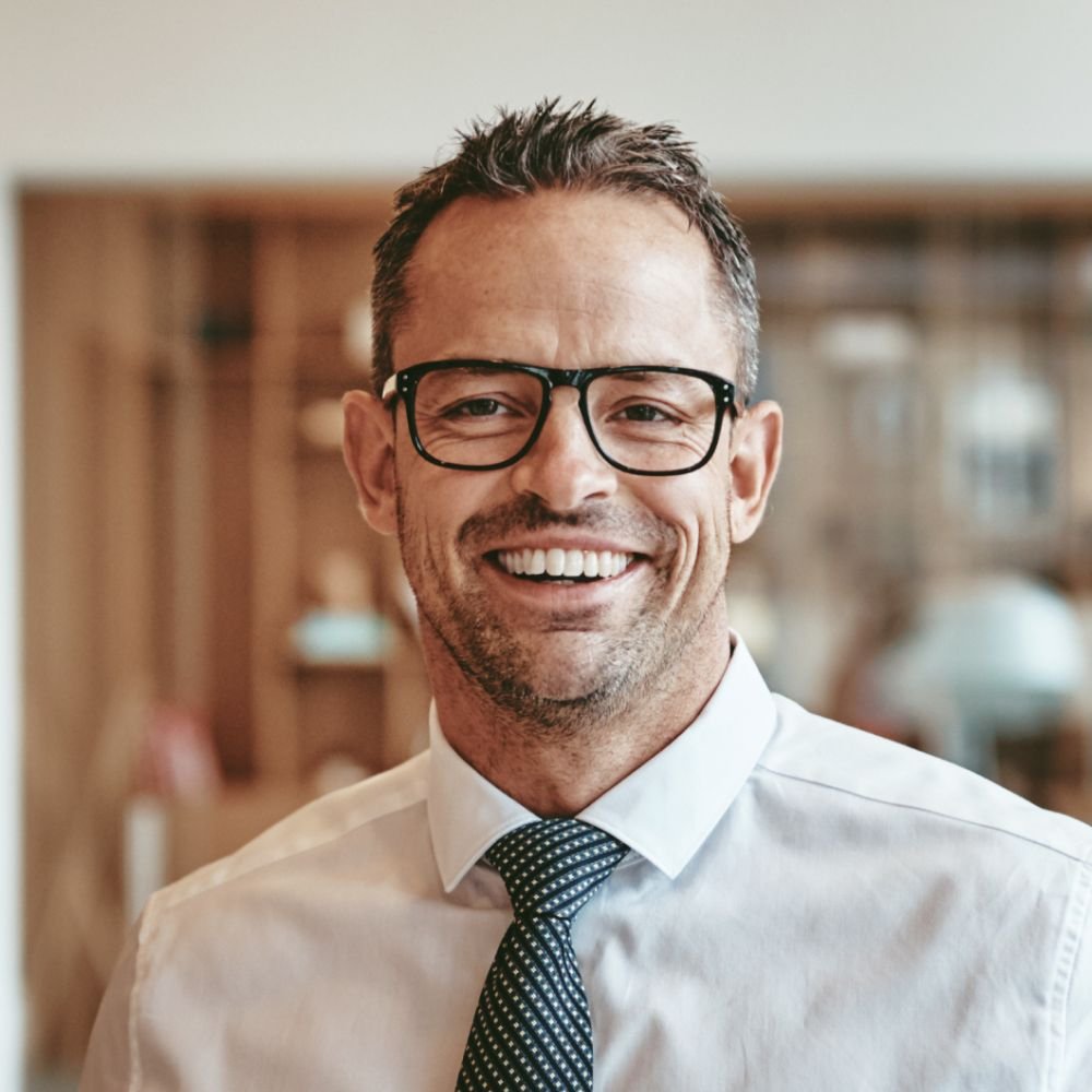 smiling mature businessman standing alone in an of y89vgbd 1 1.jpg